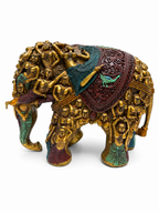 Angled view of antique gold figural elephant sculpture with teal and burgundy accents