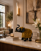 Black and gold elephant sculpture displayed in an elegant home interior