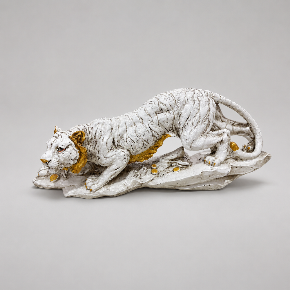 Ivory and gold crouching tiger sculpture on a rocky base, front profile