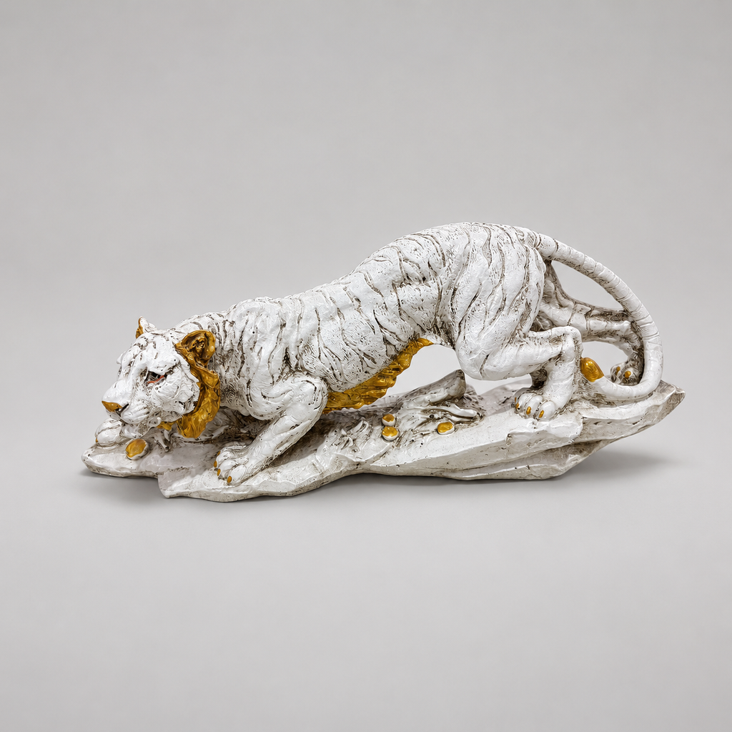 Ivory and gold crouching tiger sculpture on a rocky base, front profile