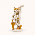 Dapper ivory and gold cat sculpture holding an umbrella, front view