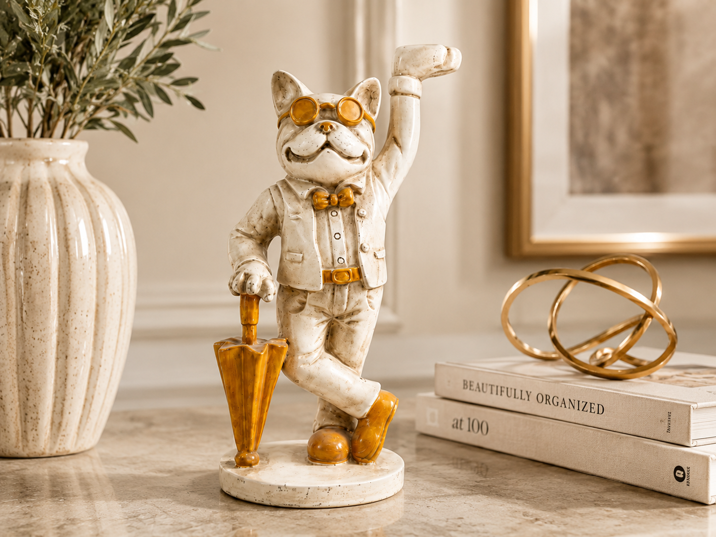Dapper ivory and gold cat umbrella sculpture styled on a console