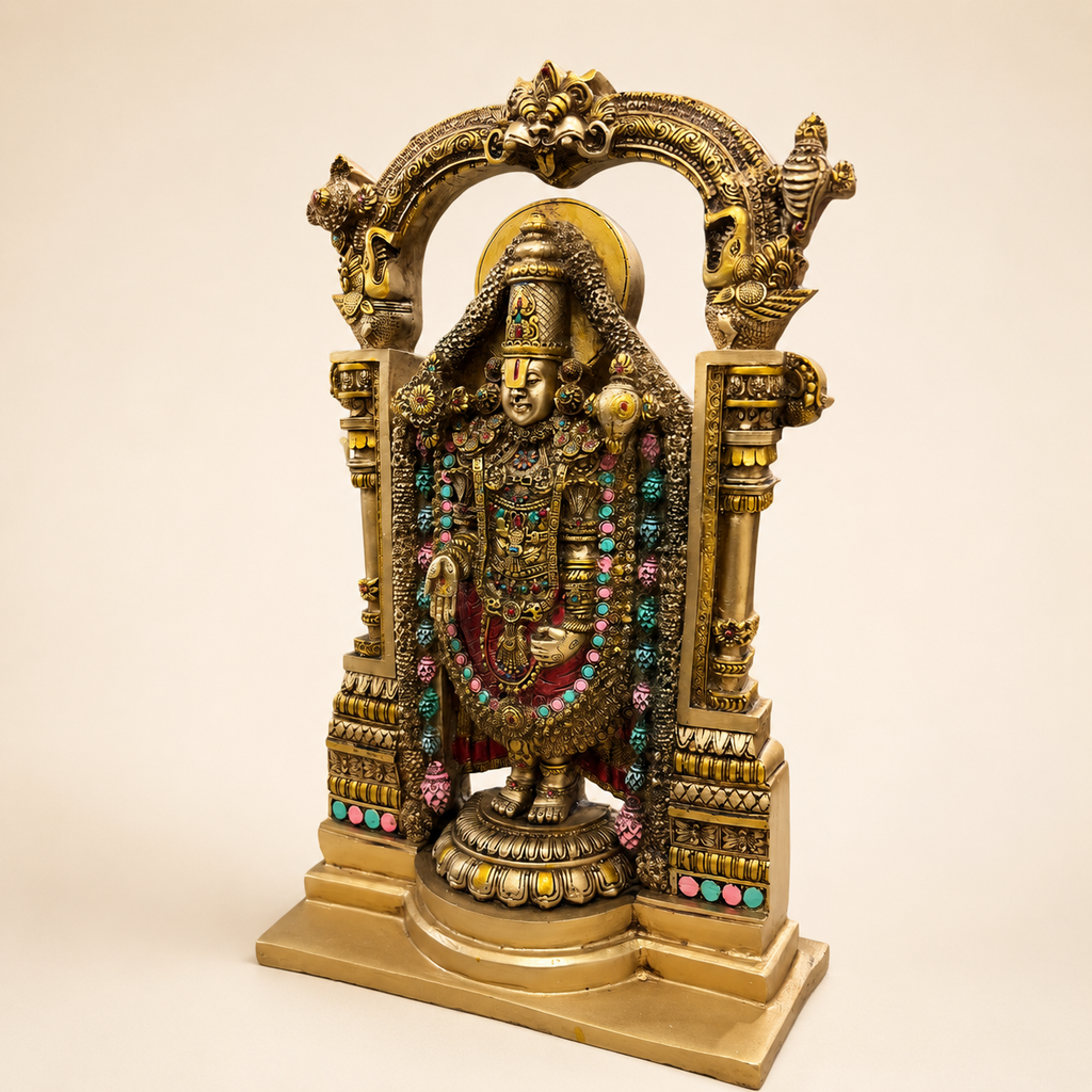 Angled view of the Tirupati Balaji idol showing the decorated temple arch, pillar details and stepped base