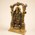 Angled view of the Tirupati Balaji idol showing the decorated temple arch, pillar details and stepped base