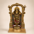 Tirupati Balaji idol beneath an ornate gold-tone temple arch, with colourful garlands and a stepped pedestal, front view