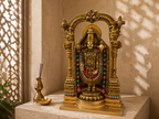 Tirupati Balaji idol displayed in a sunlit stone shrine with incense and a diya