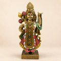 Shrinathji idol standing with one arm raised, ornate gold-tone jewellery, a red garment and green drape, front view