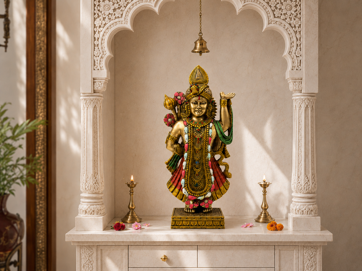 Divine Grace Shrinathji idol displayed in a white home mandir with a hanging bell and lamps