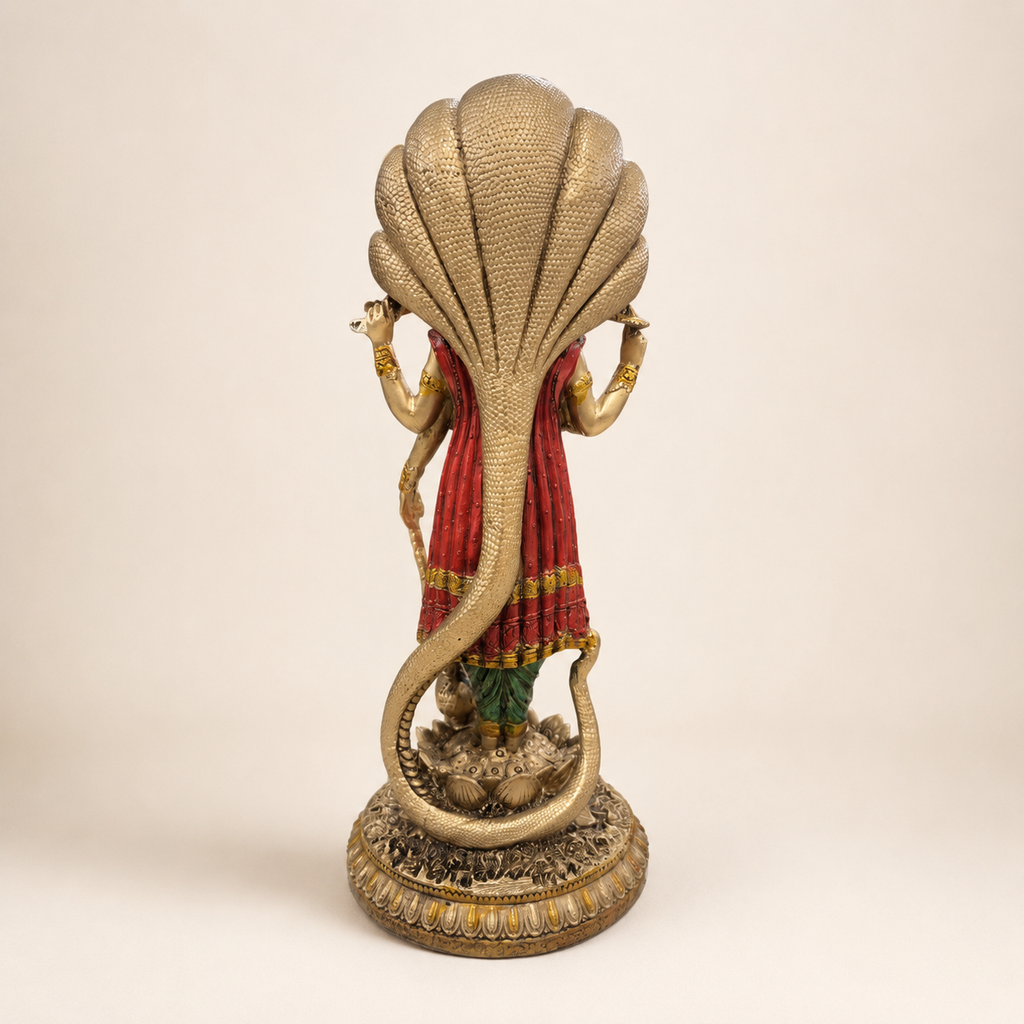 Rear view of the Vishnu idol showing the textured serpent canopy and curved body, red drape and ornate lotus pedestal