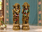 Radha–Krishna idol pair styled on a marble altar against a teal floral backdrop