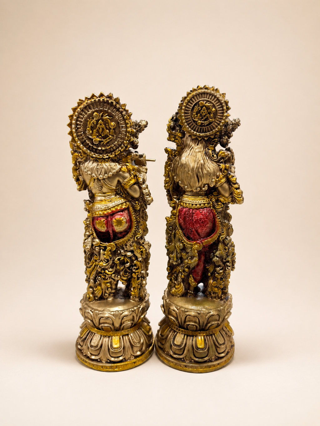 Rear view of the Radha–Krishna idol pair showing ornate halo details and individual lotus-style bases