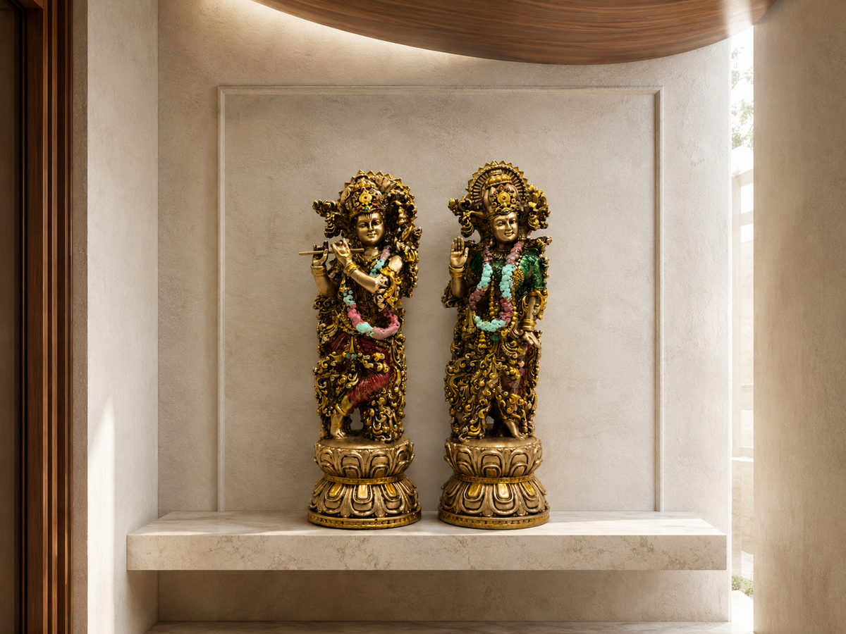 Radha–Krishna idol pair displayed in a softly lit marble wall niche