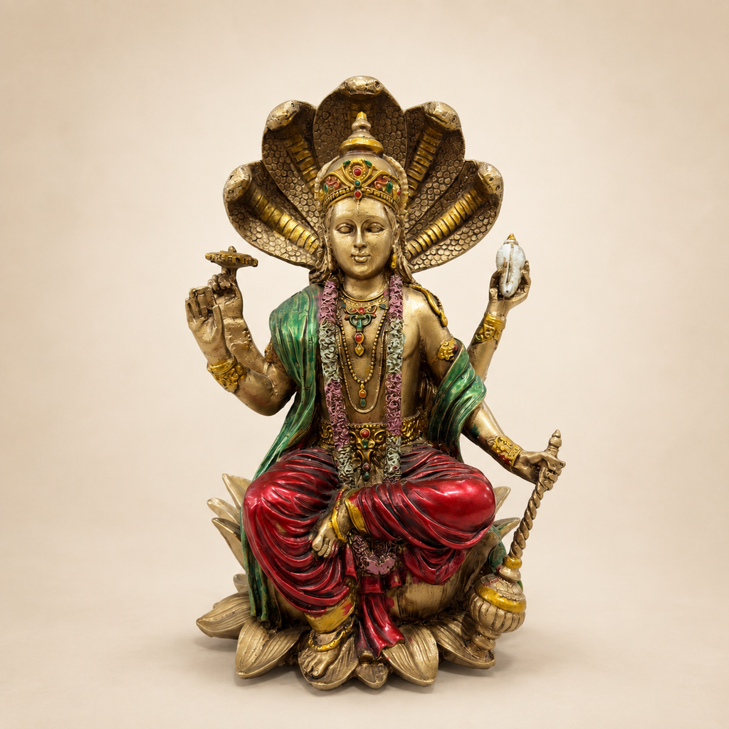 Lord Vishnu seated on a lotus beneath a five-headed serpent canopy, with a gold-tone finish and red and green garments, front view