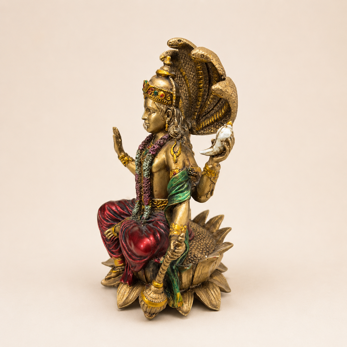 Side view of the Vishnu idol showing the conch, mace, serpent canopy and layered lotus base