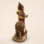Side view of the Durga idol and lion showing the ornate crown, multiple arms and textured base