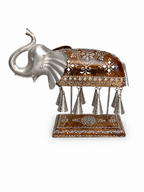 Side view of decorative elephant bell sculpture on patterned base