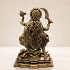 Rear view of the Maa Kali idol showing flowing hair, a floral halo and the decorated pedestal