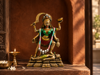 Maa Kali idol displayed in a warm terracotta prayer alcove beside a lamp
