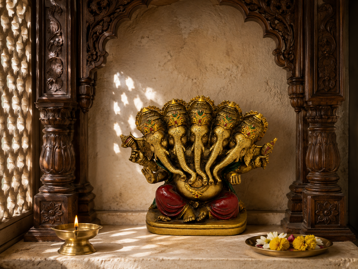 Panchmukhi Ganesha idol displayed in a carved shrine setting beside a diya and a plate of flowers