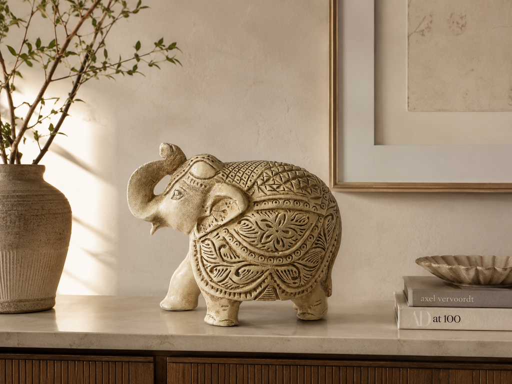 Ivory and gold ornate elephant sculpture styled on a warm neutral console