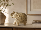 Ivory and gold ornate elephant sculpture styled on a warm neutral console