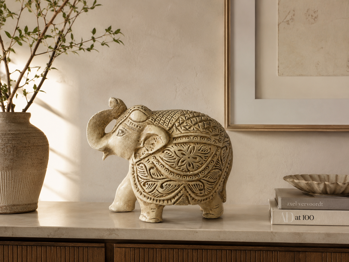 Ivory and gold ornate elephant sculpture styled on a warm neutral console