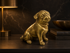 Golden pug sculpture styled on a dark console