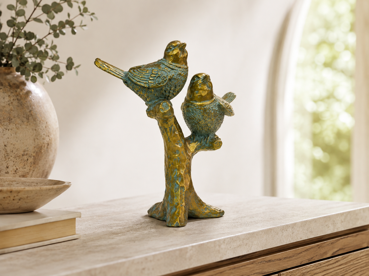 Antique teal and gold songbird sculpture styled on a console