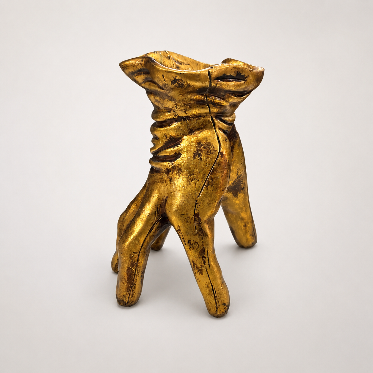 Golden hand-shaped decorative pot, angled view