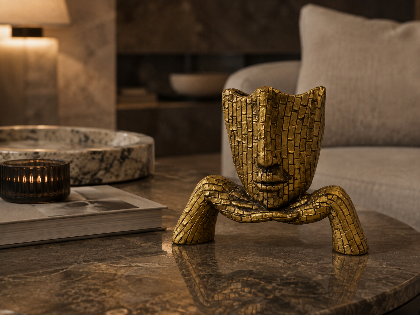 Golden mosaic face sculpture styled on a dark marble table