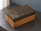 Close angled view of the floral medallions and paisley motifs on the keepsake box lid