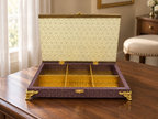 Six-compartment jewellery organiser with hinged ivory-coloured lid displayed open on a wooden table