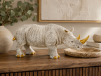 Ivory and gold rhino sculpture styled on a wooden console