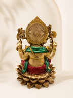 Rear view of the Ganesha idol showing the decorated halo, green shawl, red dhoti and lotus base