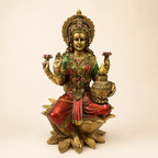 Lakshmi idol seated on a lotus pedestal with a decorative kalash, gold-tone finish, red sari and green accents, front view