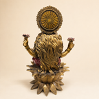 Rear view of the Lakshmi idol showing flowing hair, a patterned circular halo and the lotus pedestal