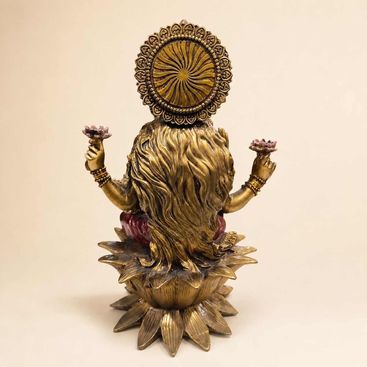 Rear view of the Lakshmi idol showing flowing hair, a patterned circular halo and the lotus pedestal