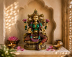 Lotus Radiance Lakshmi idol in a warm shrine setting beside a pink lotus, lamps and a gold-tone vessel