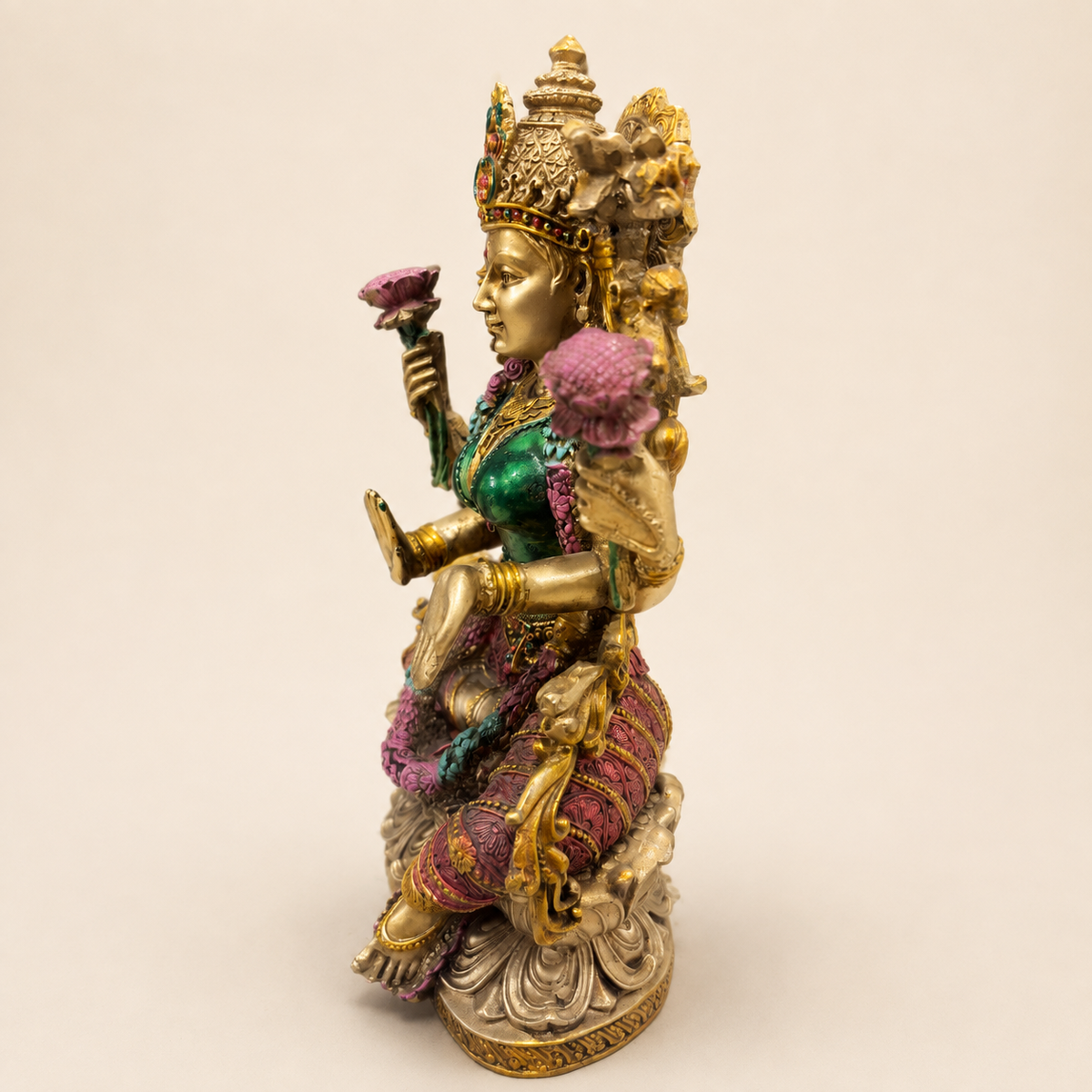 Side view of the Lotus Radiance Lakshmi idol showing pink lotus flowers, the ornate crown and sculpted lotus pedestal