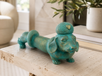 Turquoise dachshund sculpture styled on a living room console, front view