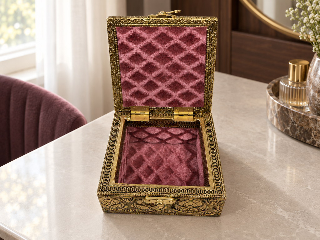 Open Mayur Bagh antique gold tone box with rose coloured lining styled on a dressing table