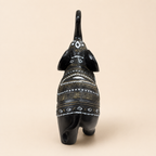 Rear view of the black elephant figurine showing ornamental bands and curved tail