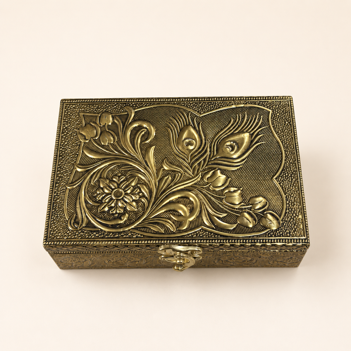 Top view of the Mor Pankh box showing raised peacock feathers, scrolling leaves and a floral medallion