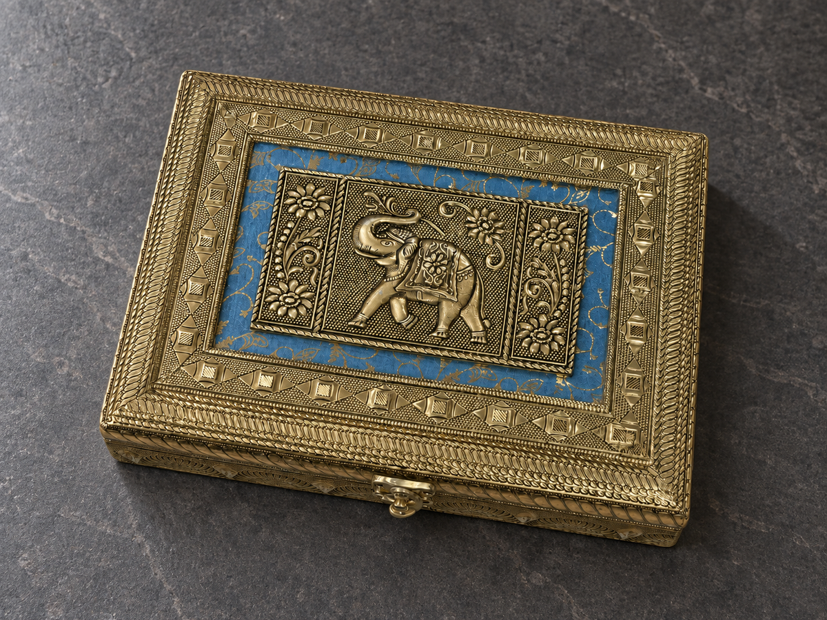 Angled detail of the elephant and floral lid panels on the Neel Gaj jewellery box on a grey stone surface