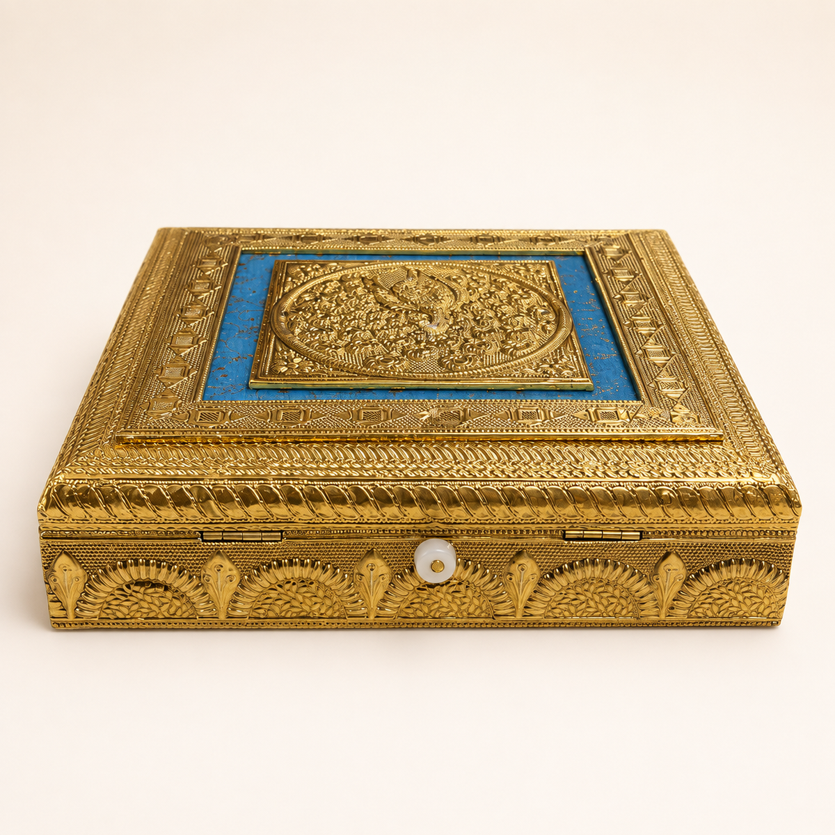 Angled view of the Neel Mayur blue and gold-tone peacock box with decorative floral side motifs