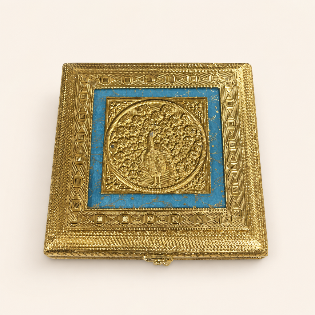 Neel Mayur square jewellery box with a gold-tone peacock motif, blue lid panel and ornate geometric borders