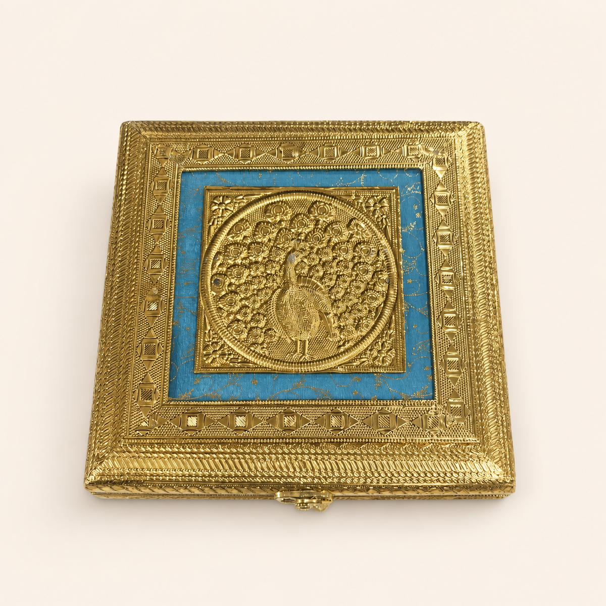 Neel Mayur square jewellery box with a gold-tone peacock motif, blue lid panel and ornate geometric borders