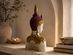 Ornate Buddha bust sculpture styled on a console, rear three-quarter view