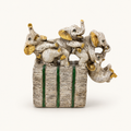 Ivory, gold, and green playful elephant parade sculpture, front view