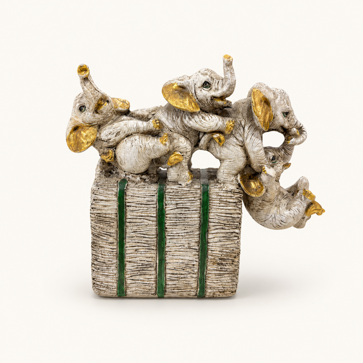 Ivory, gold, and green playful elephant parade sculpture, front view